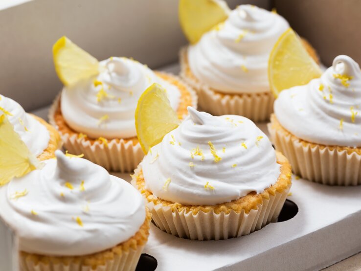 Frontalsicht: Zitronen-Cupcakes mit süßem Hut in Muffin-Formen